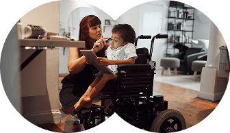 A child using a powered wheelchair being supported at home