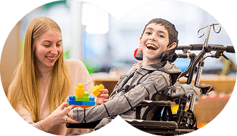 A child using a wheelchair playing with a support worker