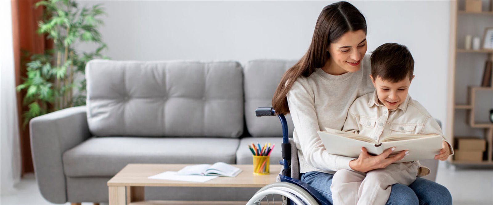 A mother using a wheelchair reading with a child at home