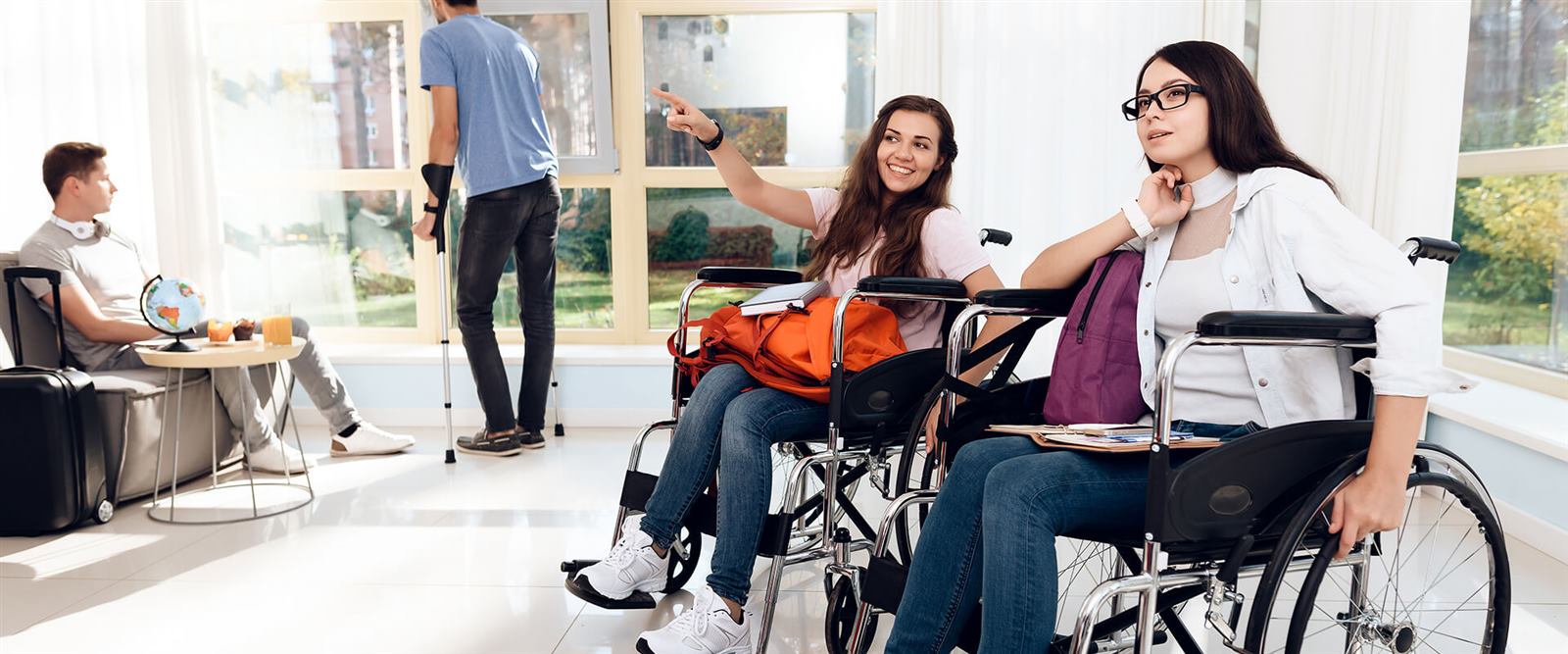 Young adults using wheelchairs and mobility aids in a bright shared space